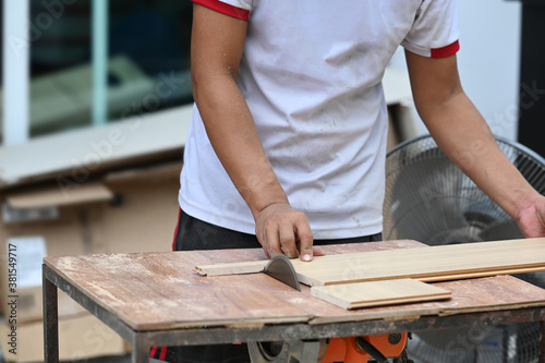 Cropped shot of carpenter working with equipment on wooden table in carpentry shop.