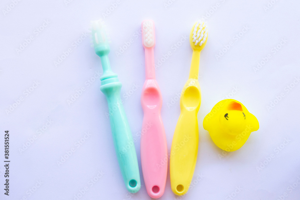 3 step tooth brush of baby 6 months ,8 months and 1 years olds with yellow duck toy health care of baby arrangement flat lay style on background white 3 step tooth brush of baby 6 months ,8 months and 1 years olds with yellow duck toy health care of baby arrangement flat lay style on background white