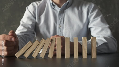 Businessman Stop Domino Effect. Risk Management and Insurance Concept.
