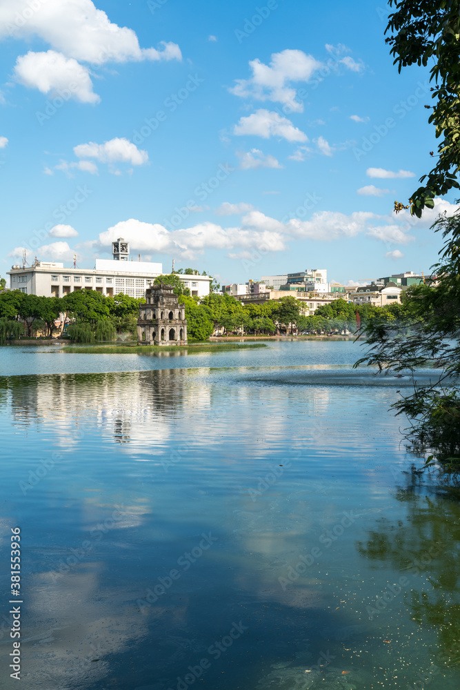 Hoan Kiem lake or Sword lake, Ho Guom in Hanoi, Vietnam with Turtle Tower, on clear day with blue sky and white clouds