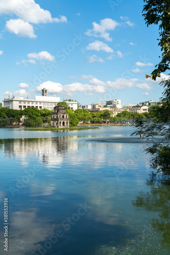 Hoan Kiem lake or Sword lake, Ho Guom in Hanoi, Vietnam with Turtle Tower, on clear day with blue sky and white clouds © Hanoi Photography