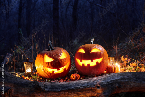 Halloween pumpkins burning in forest at night