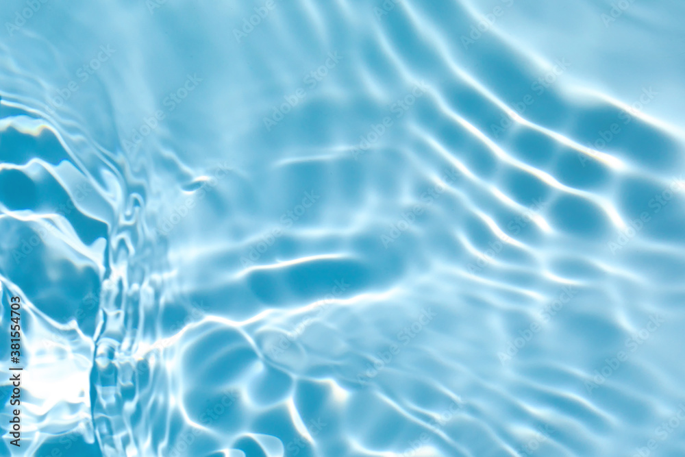 De-focused blurred transparent blue colored clear calm water surface texture with splashes and bubbles. Trendy abstract nature background. Water waves in sunlight with copy space. De-focused blurred transparent blue colored clear calm water surface texture with splashes and bubbles. Trendy abstract nature background. Water waves in sunlight with copy space.