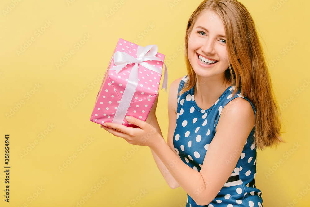girl in dress on yellow background holds gift box girl in dress on yellow background holds gift box