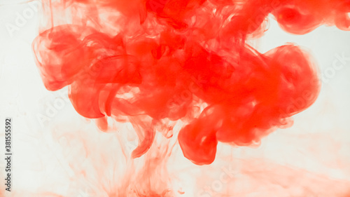 Red ink drop in water on white background. Watercolor paint splash abstract.