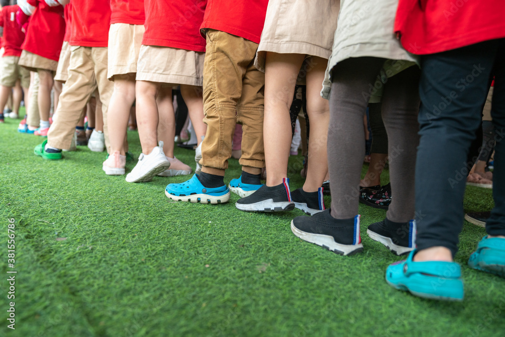 Obraz premium Queue of Asian kids in school uniform standing in line