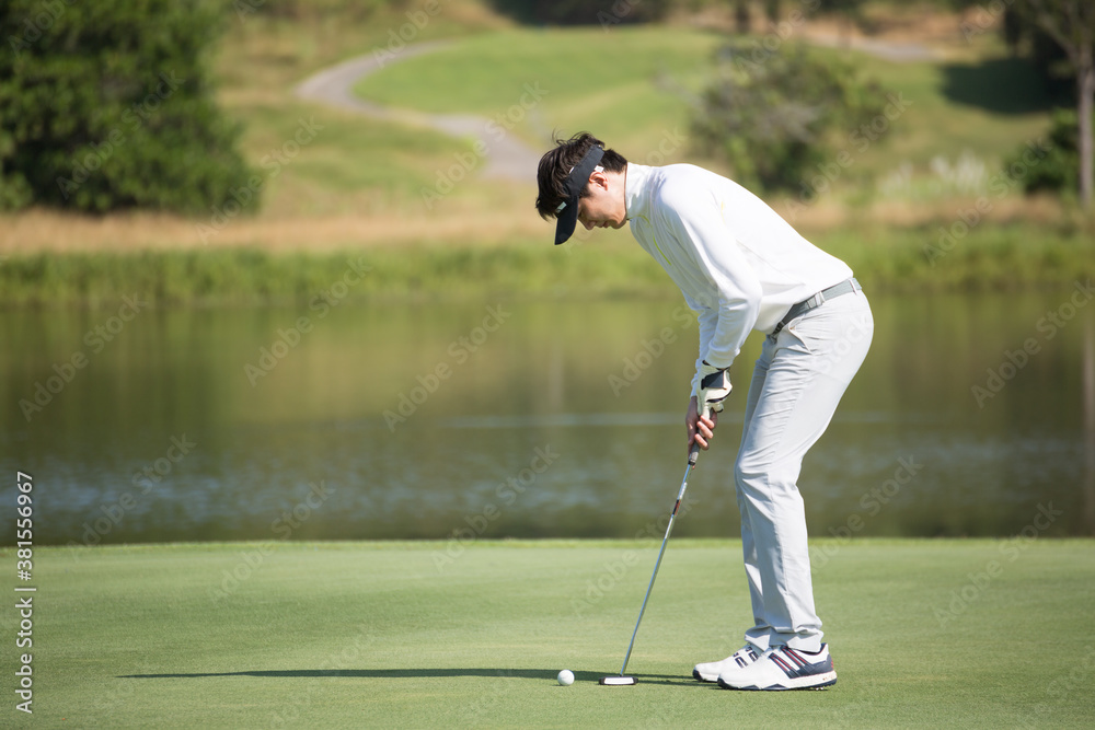 Fototapeta premium Golfers putting golf balls on the green amid the warm sunshine in the morning. Concept of Outdoor activities and Outdoor sports, Concept of Golfer and Lifestyle..