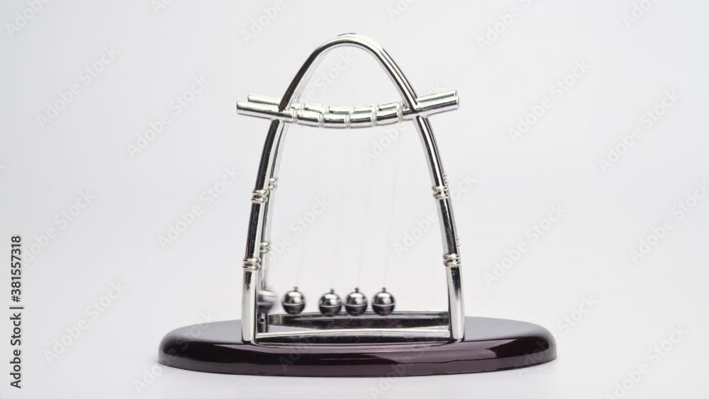 Newton's Cradle metal balls on white background, swinging metal balls. Close up. Newton's Cradle metal balls on white background, swinging metal balls. Close up.
