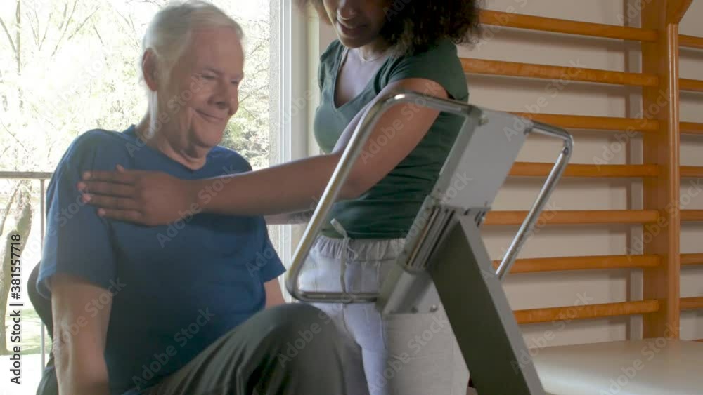 Elderly man at the gym helped by african female trainer Elderly man at the gym helped by african female trainer