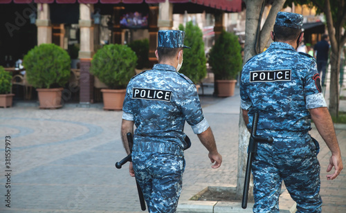 Caucasian two police man walking in city.
