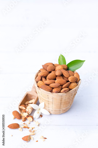 Almond nuts in basket isolated on white wooden background, Almonds are healthiest nuts and one of the best brain foods.Selective focus. photo