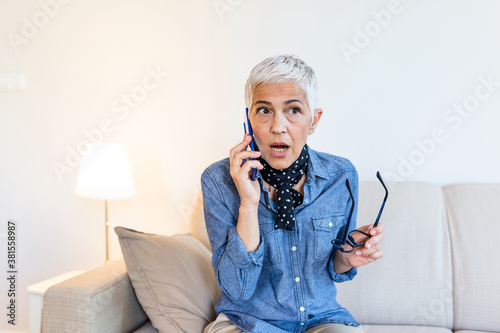 Tableau sur toile Ederly female having phone conversation with her old friend using cellphone, dis