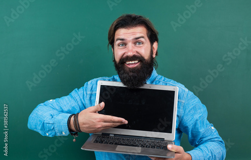 cheerful successful and confident guy with beard working on laptop online, modern life