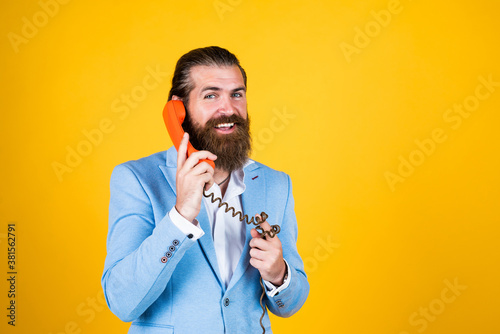 Say it with phones. Bearded man with telephone handset. business call concept. man talking to vintage phone. bearded man in a suit holding retro phone. stay connected. customer service concept