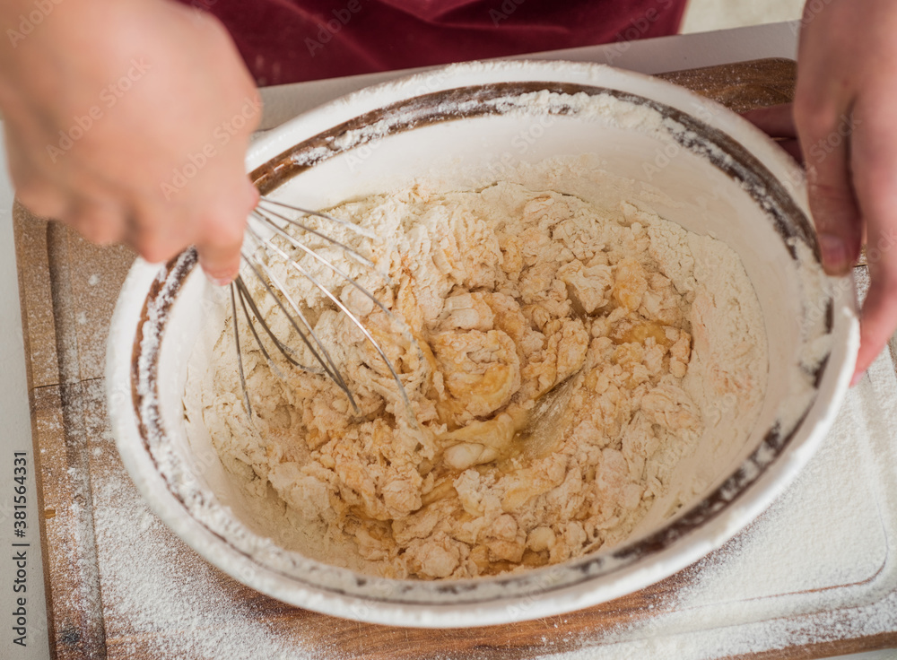 child beating egg and flour for making dough with beater, cook child beating egg and flour for making dough with beater, cook