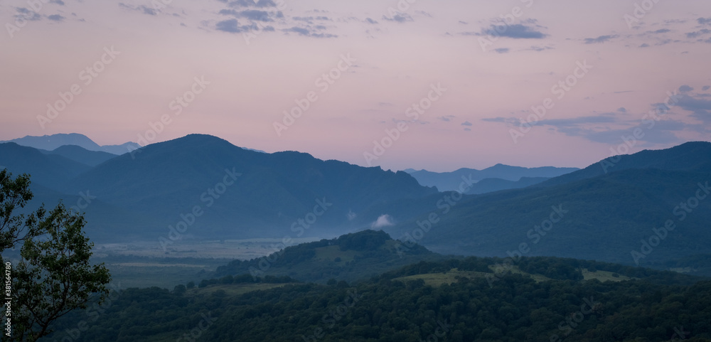 Early morning one hour before dawn. Silhouettes of mountains in the morning haze. Lagonaki Plateau, Republic of Adygea, Russia