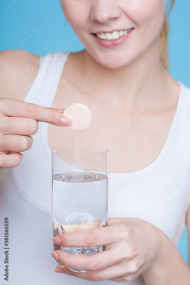 Woman holding glass with water and effervescent tablet Woman holding glass with water and effervescent tablet