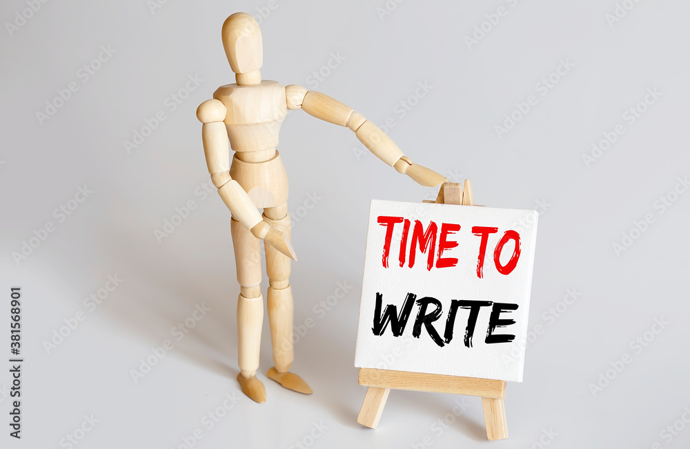 Wooden man shows with a hand to white easel with text TIME TO WRITE on white background Wooden man shows with a hand to white easel with text TIME TO WRITE on white background