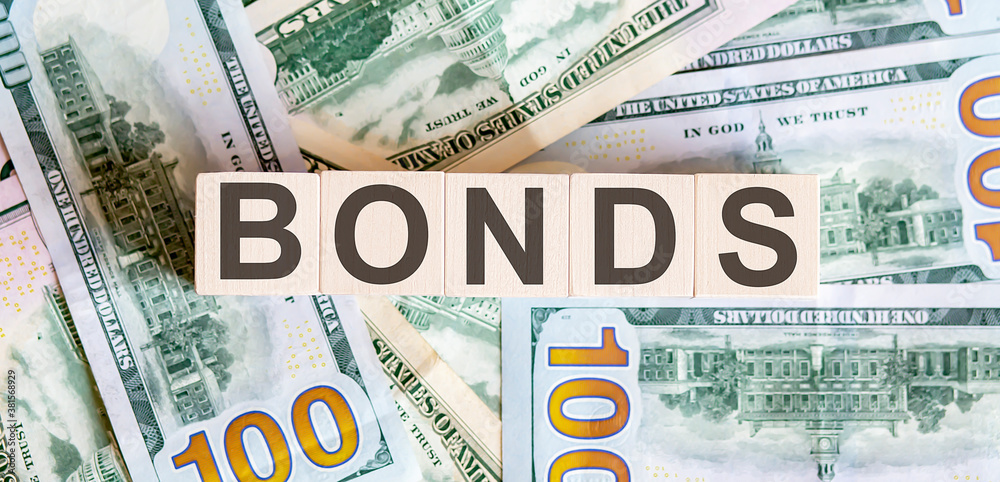 Concept words BONDS on wooden blocks on a beautiful background from dollar bills. Concept words BONDS on wooden blocks on a beautiful background from dollar bills.