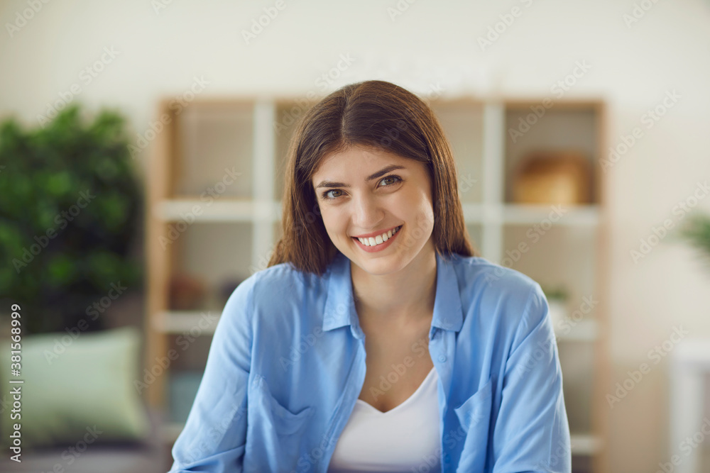 Portrait of friendly young good looking online tutor looking at web camera during video call