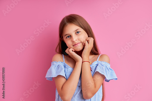 pretty young caucasian girl dream about something, wearing summer dress, isolated pink background