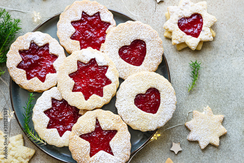 Plate with Christmas or New Year shortcrust cookies with red jam. Traditional festive Austrian cookies with jam. Linzer cookies.