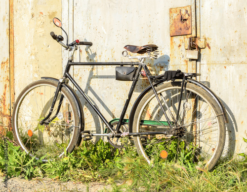 Old bike stands on the street on a summer day © Natalya
