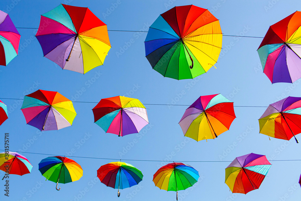Multi-colored umbrellas on the blue sky background.