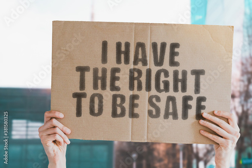 Fotografi The phrase  I have the right to be safe  on a banner in men's hand with blurred background