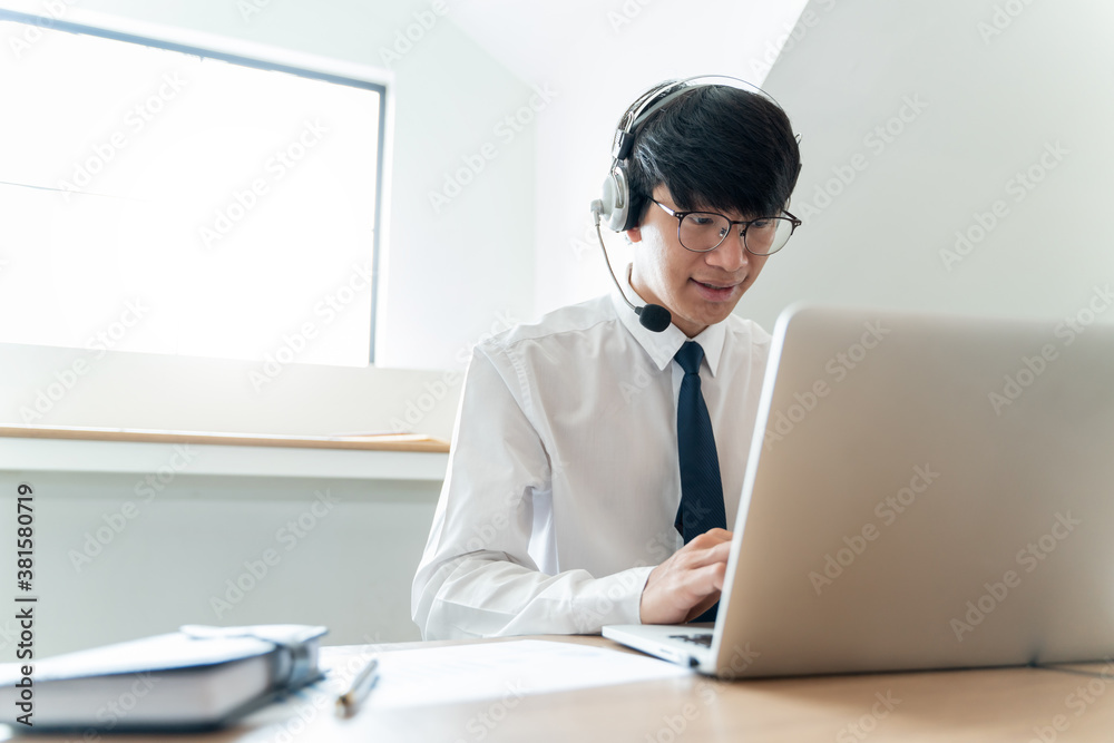 Online working concept, Asian male wearing headphone video calling in online conference. Online working concept, Asian male wearing headphone video calling in online conference.