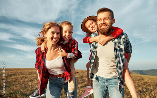 Happy family: mother, father, children son and daughter playing in nature against a blue sky. photo