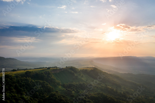 Early morning in the mountains. Morning sun and haze in the valley against the background of mountains. Mountain summer landscape. Lagonaki Plateau, Republic of Adygea, Russia