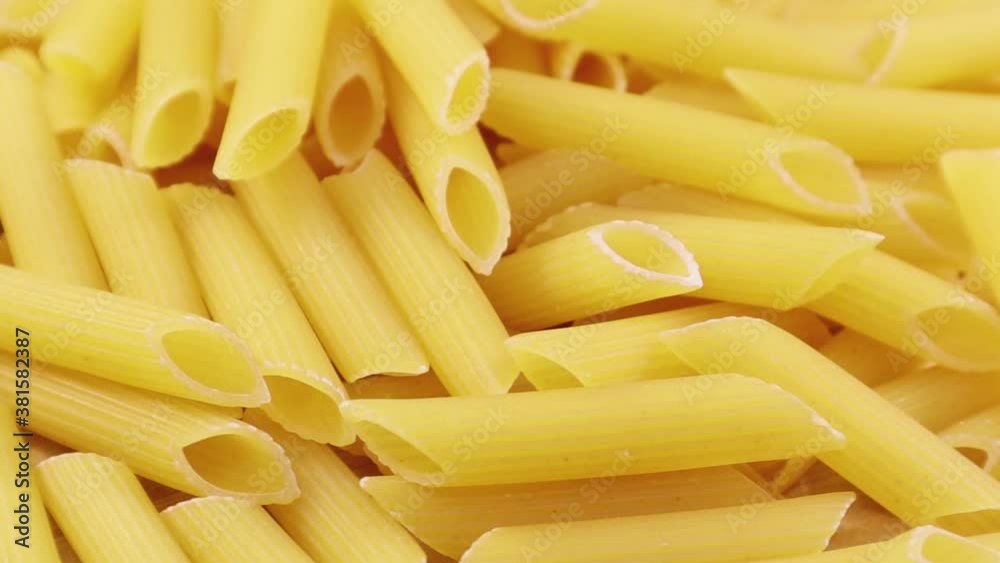 Slowly spinning raw Penne Rigate is a short pasta with oblique cuts and a ribbed surface. Traditional Italian pasta. Doesn't get stuck. View from above. Slowly spinning raw Penne Rigate is a short pasta with oblique cuts and a ribbed surface. Traditional Italian pasta. Doesn't get stuck. View from above.