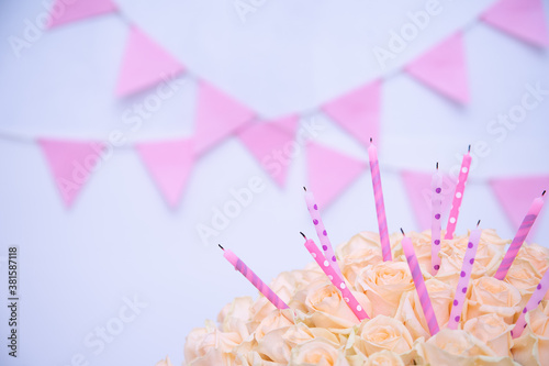 Cream pastel rose with holiday candles on a celebrating purple background