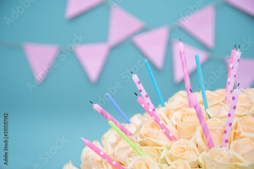 Cream pastel rose with holiday candles on a celebrating blue background