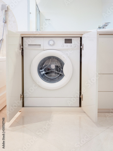 Wallpaper Mural Close up on hidden washing machine in the bathroom. Embedded laundry machine with open and closed doors. Washer enclosed in the lavatory. Torontodigital.ca