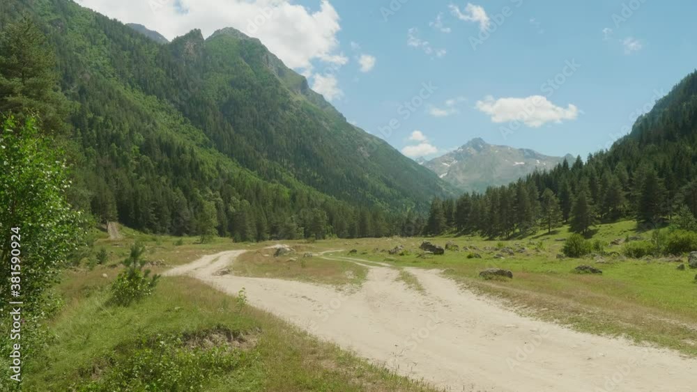 Country road in ravine Makhar in Russia. Picturesque place with blue sky and white clouds above. Country road in ravine Makhar in Russia. Picturesque place with blue sky and white clouds above.