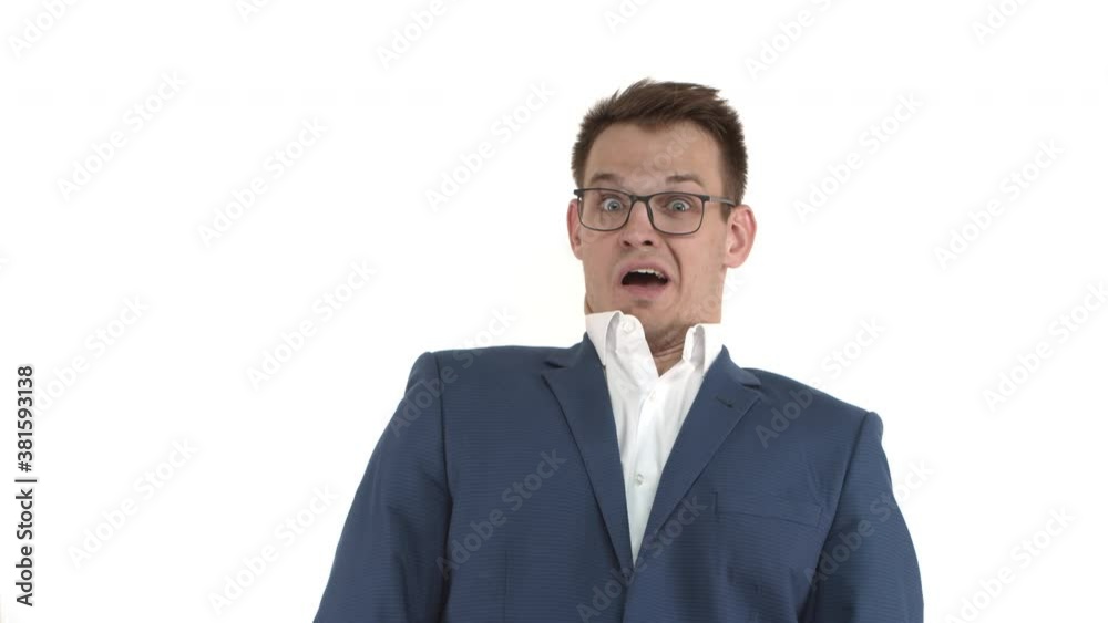 Handsome funny businessman in blue suit and glasses looking shocked, drop jaw and tilt back startled with news, standing over white background Handsome funny businessman in blue suit and glasses looking shocked, drop jaw and tilt back startled with news, standing over white background