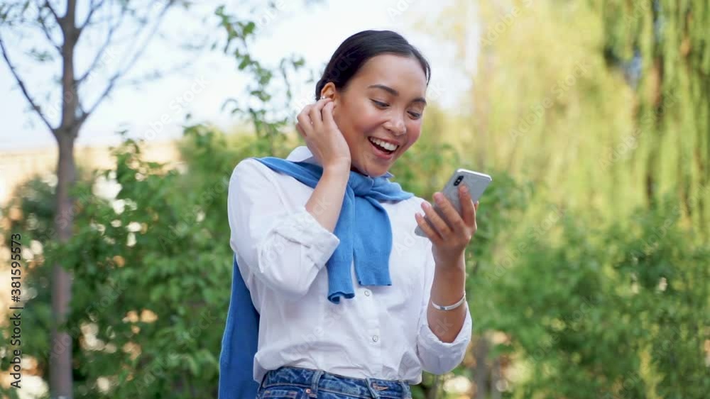 Successful asian woman receives a message on the phone and gets excited. Medium shot. Successful asian woman receives a message on the phone and gets excited. Medium shot.