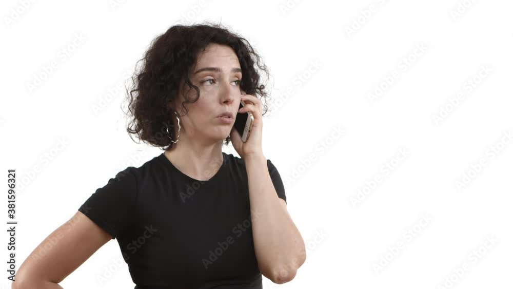 Close-up of young attractive female model with curly hair, wearing black t-shirt, having phone call and looking dissatisfied, shaking head and saying no, disagree or deny something bad Close-up of young attractive female model with curly hair, wearing black t-shirt, having phone call and looking dissatisfied, shaking head and saying no, disagree or deny something bad