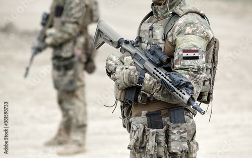 Φωτογραφία Soldiers with machine gun and flag of Syria on military uniform