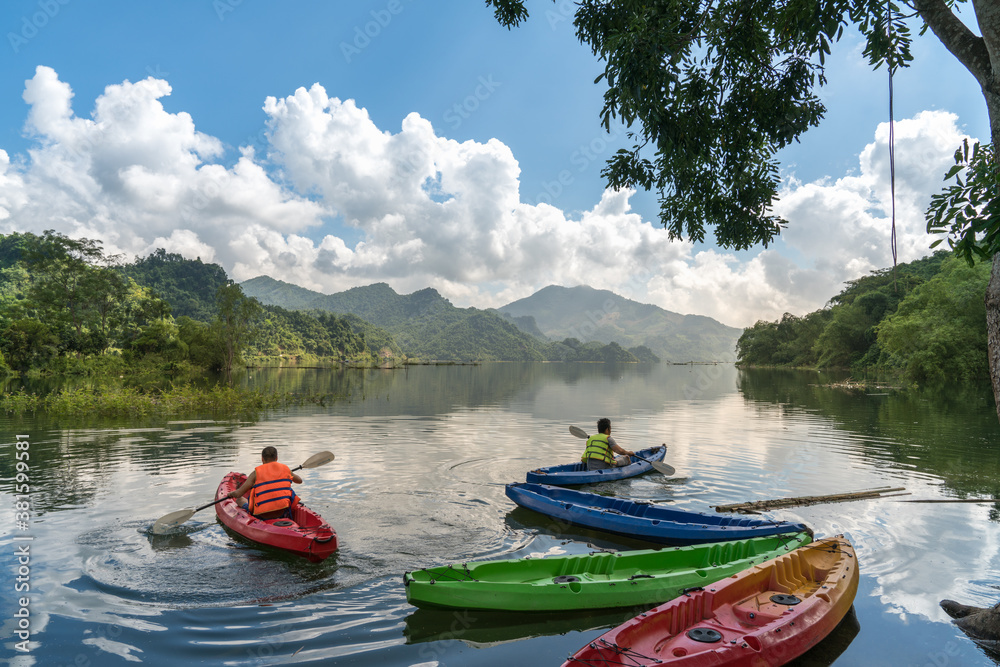 Landscape in Hoa Binh province, Vietnam, with people kayaking on the river