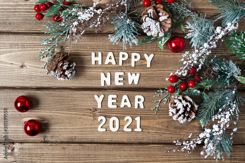 Happy new year 2021 composition. Christmas fir branches decorations on old dark wooden background with letters text, flat lay top view