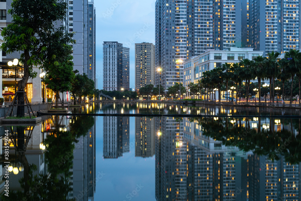 Obraz premium Twilight scene of modern city with buildings and reflection on lake in Hanoi, Vietnam