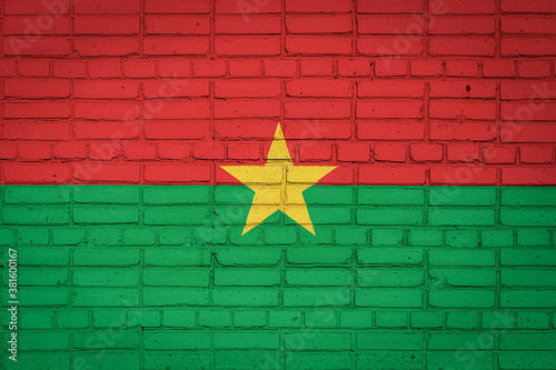 National flag of Burkino Faso depicting in paint colors on an old brick wall. Flag  banner on brick wall background. photo