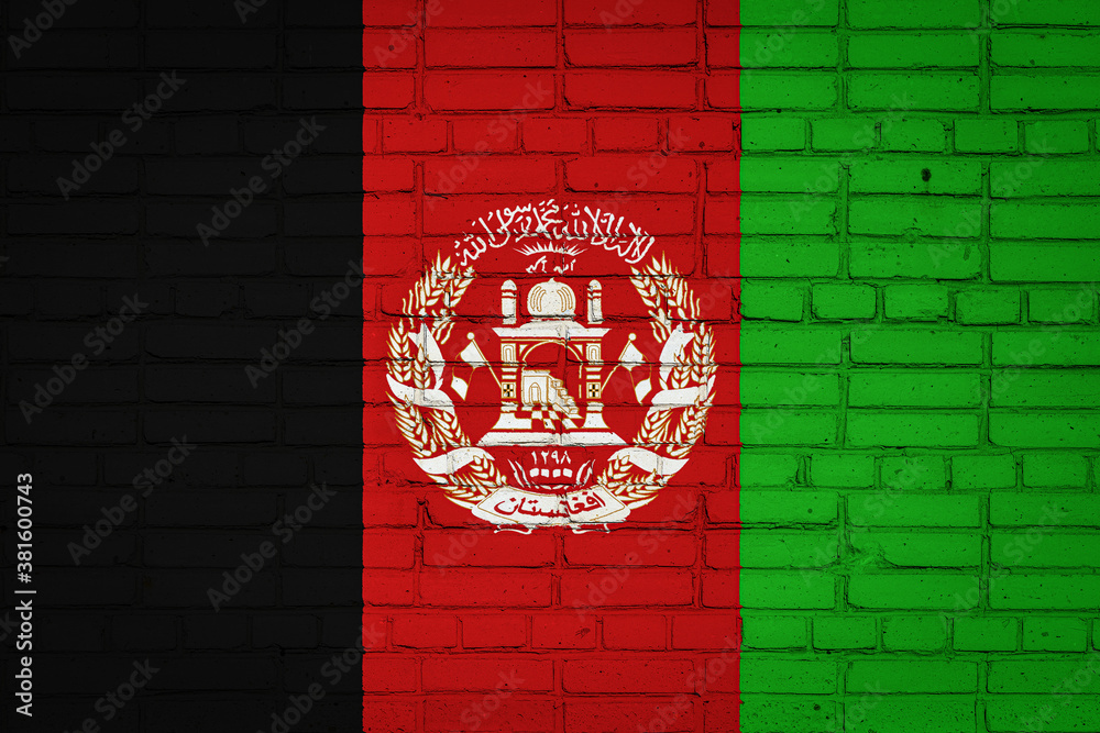 Obraz premium National flag of Afghanistan depicting in paint colors on an old brick wall. Flag banner on brick wall background.