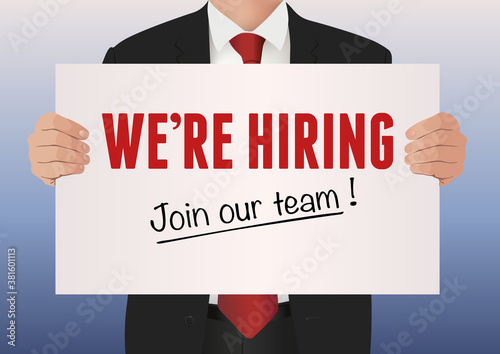 Un manager responsable des ressources humaines, présente un panneau blanc pour informer que son entreprise recrute.