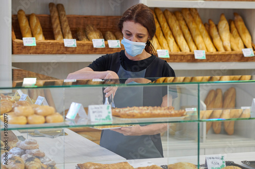 young red-haired worker working in the bakery. Small business concept. protection measures against covid 19 in small businesses