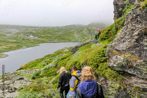 Hikers on the Hydnefossen waterfall Hydna river in Hemsedal, Norway. photo