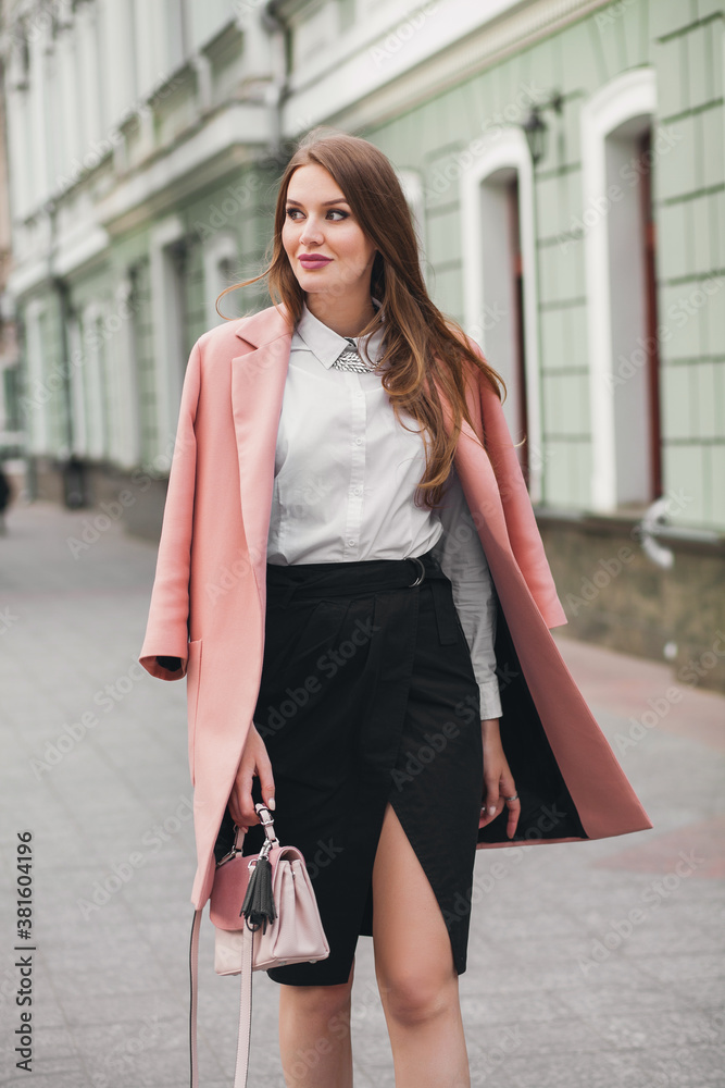 Fototapeta premium young stylish beautiful woman walking in street, wearing pink coat, purse, white shirt, black skirt, fashion outfit, autumn trend, smiling happy, accessories
